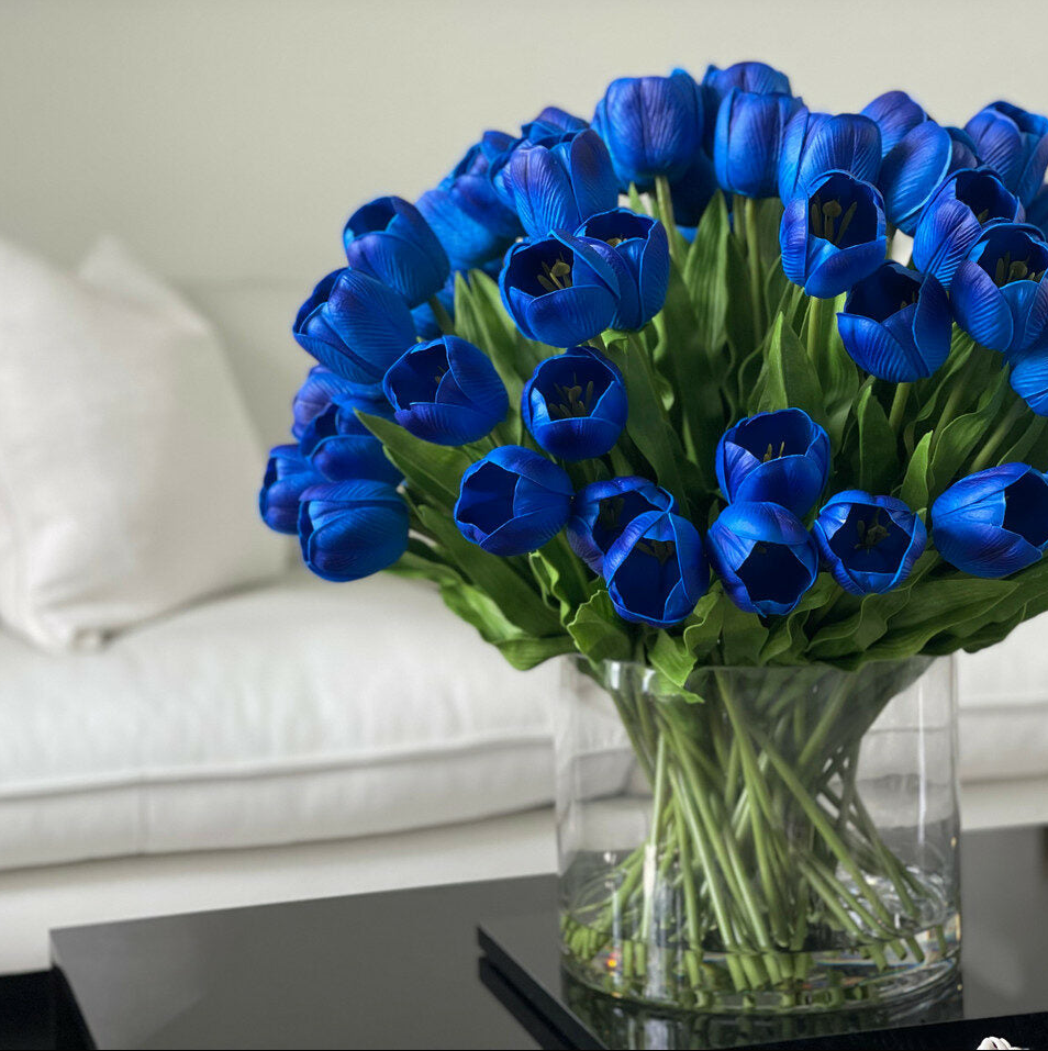 azul tulipán arreglo en un grande Cylindrical jarrón