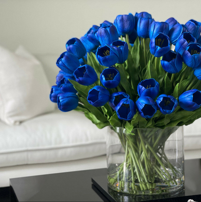 azul tulipán arreglo en un grande Cylindrical jarrón
