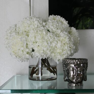 blanco hortensia ramo en clear vidrio cilindro jarrón