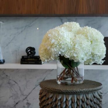 blanco hortensia ramo en clear vidrio cilindro jarrón